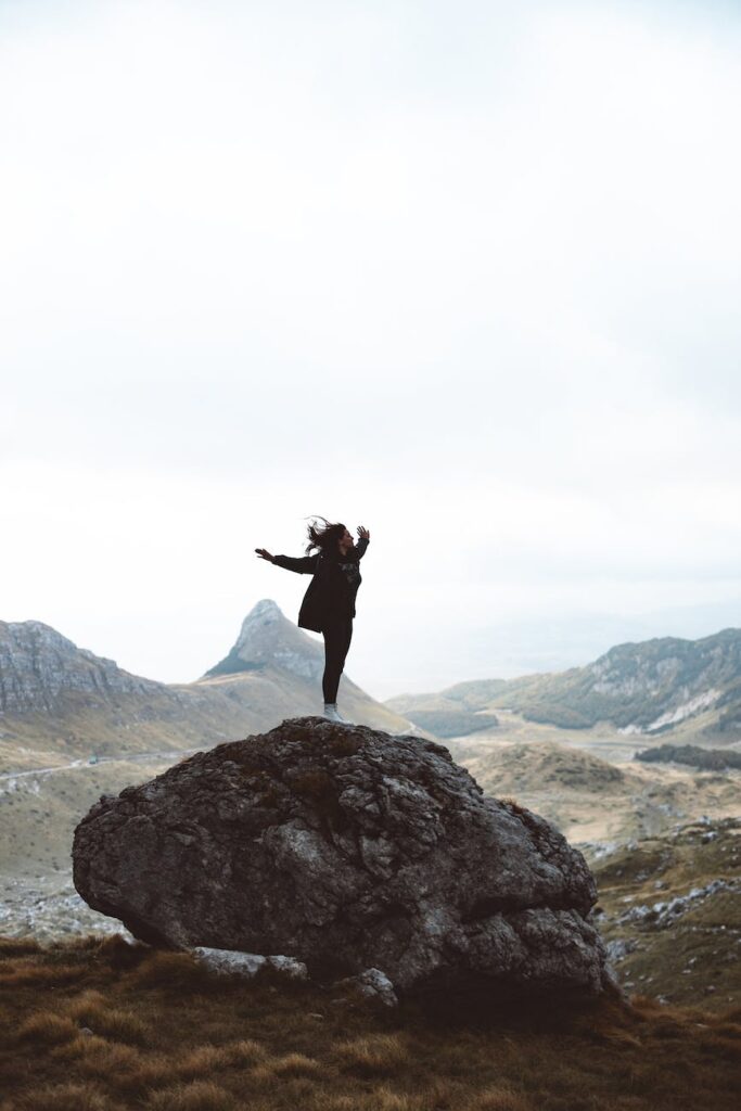woman standing on boulder